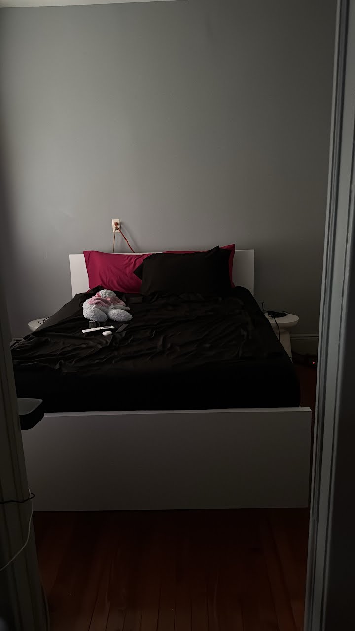 White platform bed made up with bedding in a tidy bedroom
